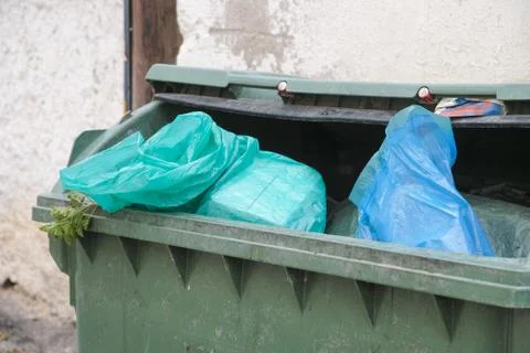 Green trash dumpster full of garbage Stock Photos