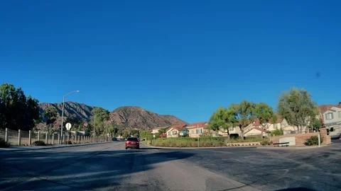 Green trees and distant peaks on a residential drive, LA Video stock 344016852