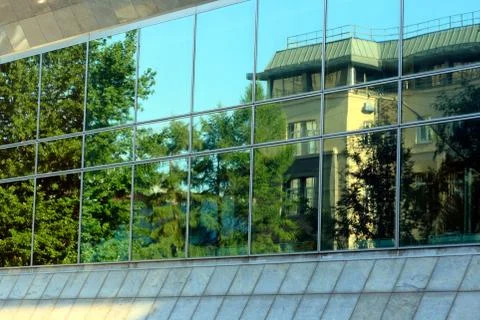 Green trees and house reflected on large window. Stock Photos