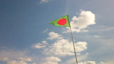 Green triangle flag with red dot against blue sky in France Stock-Footage 135311990