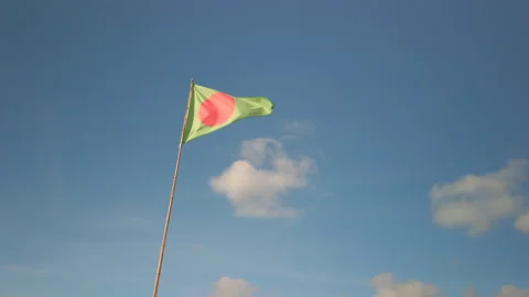 Green triangle flag with red dot indicating a surfing area, blue sky, in France Stock-Footage 135404924