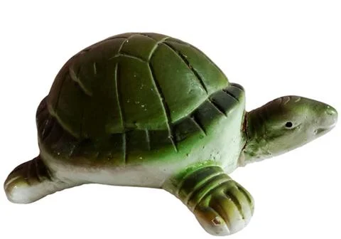 A green turtle statue on a white background. Stock Photos