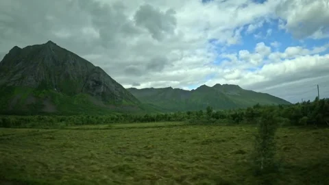 Green valley, birch trees, power lines, and steep mountain peaks in Senja Norway Stock-Footage 342340418
