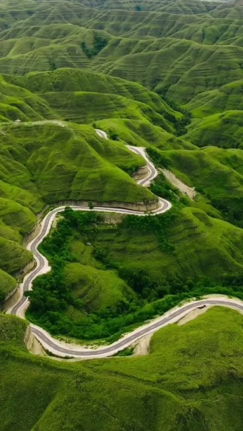 Green Valley Under Clouds with Scenic Road Above Stock Footage 310073309