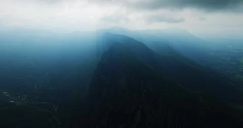 Green Valleys On Both Sides Of Large Mountain Range Summit Cliffs On Misty Stock Footage 289411820