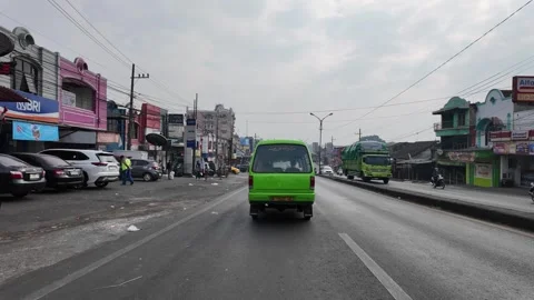 Green van drives down wet street Stock Footage 345157144