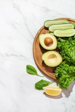 Green vegetables on a white table. Background with salad ingredients. Healthy Stock Photos