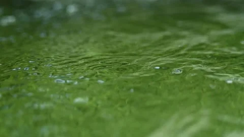 Green water with bubbles in a natural pool in the mountains (slow motion, bokeh) Stock-Footage 211760810