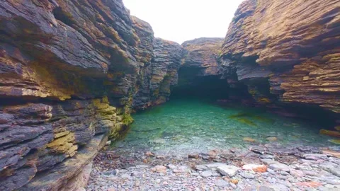 Green water pool nestled between rocky cliff walls Stock Footage 340450723