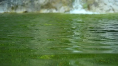 Green water of a pool next to a waterfall in the mountains (slow motion) Stock-Footage 211762701