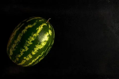 Green watermelon on a dark background. Top view, copy space, healthy food Stock Photos
