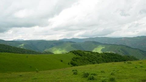 Green waves of mountains panorama under a cloudy sky Stock Footage 342713048
