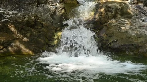 Green waves on a pool from a mountain stream 스톡 동영상 260844025
