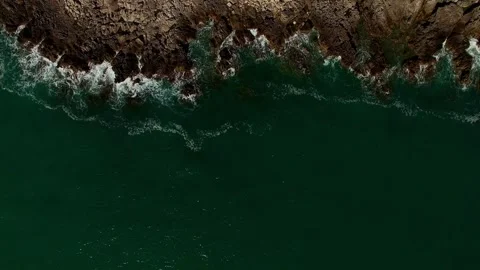 Green waves roll foaming on the rocks. Top view Stock Footage 269440901
