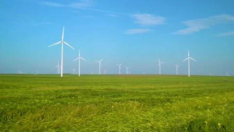 Green wheat field in motion with wind turbines in the background. Spring season. Stock-Footage 150663122
