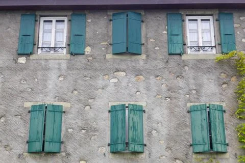 Green windows on the wall of building Stock Photos
