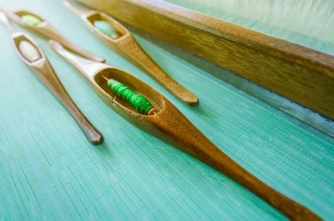 Green yarn in weaving shuttle tool on weaving machine. Textile fabric weave.  库存照片