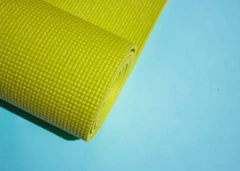 A green yoga pilates exercise mat rolled up. International Yoga Day June 21st Stock Photos