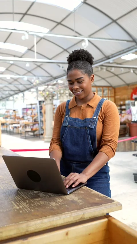Greenhouse worker managing online orders on laptop Stock Footage 311304668