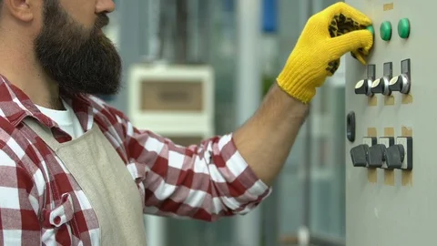 Greenhouse worker pressing buttons regulating heating, plant growth conditions Stockbeeldmateriaal 118909990