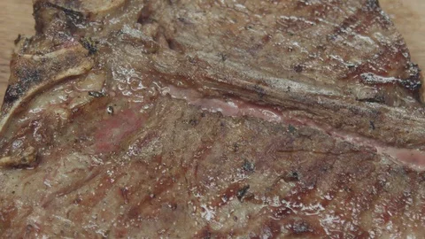 The greens fall on an appetizing medium rare steak Stock Footage 128830434