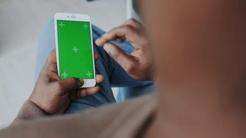 Greenscreen or Mock-up Tracking. Afro man with Vertical Mobile Touch pad with Stock Footage 120687084