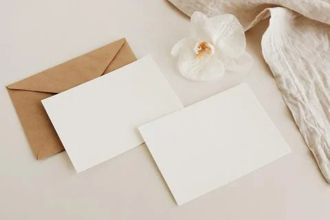 Greeting Cards mockup, empty white blanks, envelopes and orchid flower top view  Stock Photos