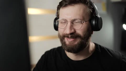 Greeting, hello concept. Friendly bearded man in headphones and glasses on video Vídeos de archivo 303948110