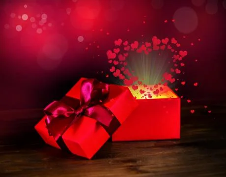 Greeting opened box with bow and miracle heart light on wooden background, St Foto stock