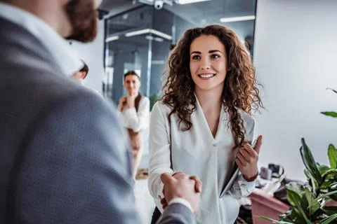 Greetings at work. Hand shaking between coworkers Stock Photos