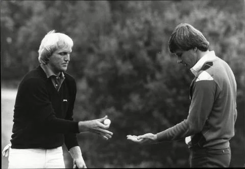 Greg Norman (left) Hands Nick Faldo His Ball During Plat At The Suntory Golf Fin Fotos de archivo
