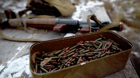 A grenade launcher is lying next to a box of ammo on a table Stock Footage 288826126