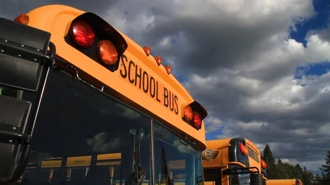 Gresham, Oregon, June 28, 2015 – School buses are parked in a row on a cloudy Stock Footage 92225586