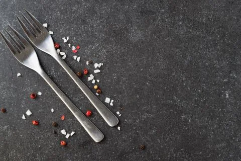 Grey abstract background with forks, salt. Place for text. Stock Photos