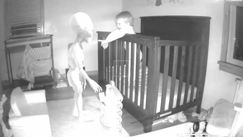 Grey alien in Childs room at night on baby monitor Stock Footage 139469824