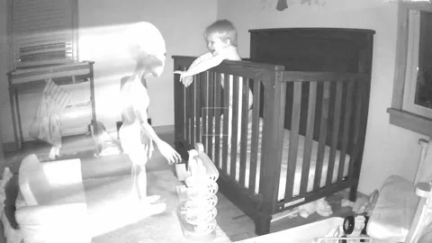 Grey alien in Childs room at night on baby monitor with glow Stock Footage 139469831