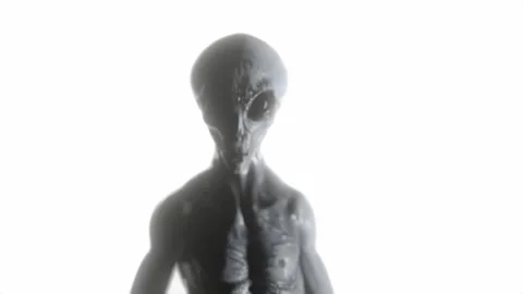 Grey Alien Walks in Focus while being surrounded by bright white light Stock Footage 323491381