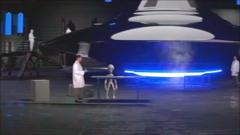 Grey Alien working with Scientists Flying Saucer UFO in Hangar Stock Footage 162196252