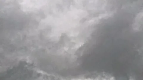 Grey and black clouds drifted slowly across the sky, creating a gloomy atmospher Stock Footage 345379220