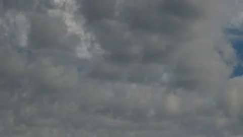 Grey and white clouds move slowly through the sky with a few patches of blue Stock Footage 151834934