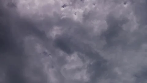 Grey and white clouds moving across an overcast sky Stock Footage 329757568
