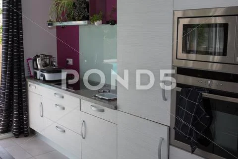 Grey and white kitchen interior in new luxury home Stock Photos