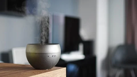 Grey aroma oil diffuser on light table at home, air freshener Video stock 264580869
