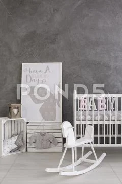 A grey baby room with a crib and a rocking horse Stock Photos