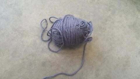 Grey ball of threads wool yarn for knitting on grey floor background Stock Photos