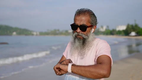 Grey bearded elderly man runs with modern fitness tracker watch in morning on Stock Footage 256011507