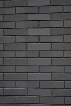 Grey brick wall presenting a rough surface texture and repeating pattern ideal Stock Photos