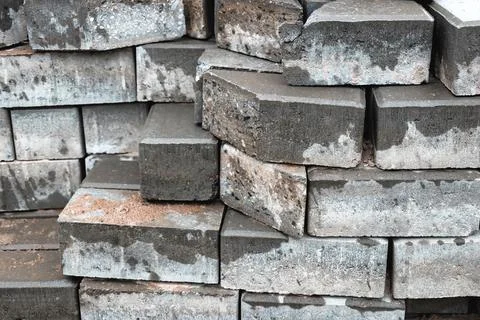 Grey bricks arranged in an overlapping pattern, showcasing their rough textur Stock Photos