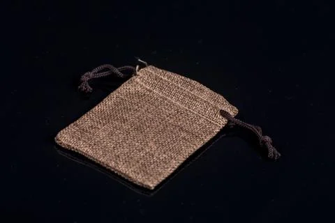 Grey burlap jute drawstring gift jewelry pouches bag isolated above black bac Stock Photos