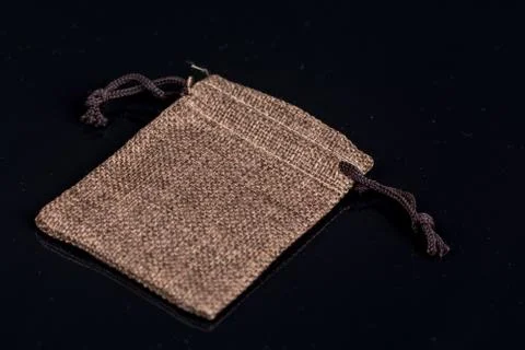 Grey burlap jute drawstring gift jewelry pouches bag isolated above black bac Stock Photos